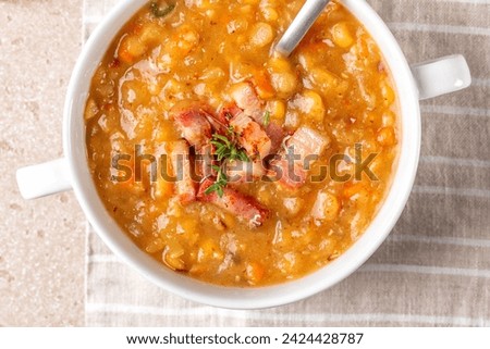 Top view oa a bowl with Creamy yellow split pea soup with smoked bacon, ham. Homemade comfort food. Royalty-Free Stock Photo #2424428787
