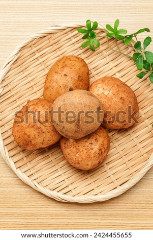 Raw unpeeled potatoes on wooden table
