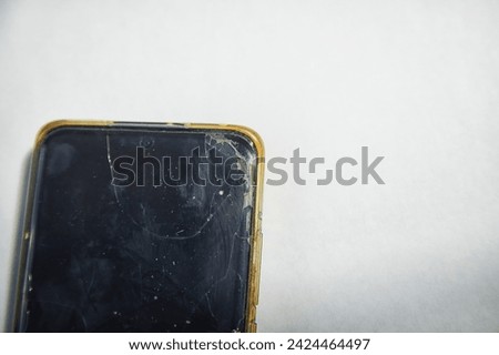 Close-Up View of a Cracked Smartphone Screen Against White Background. the detailed texture of a shattered smartphone screen, emphasizing extensive damage to the device