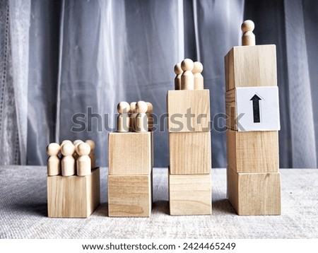 Wooden toy doll on high pedestal and many other figures below. Concept of leadership, which is not available to everyone. Victory and the winner. Talent, Recruitment employee and Successful business Royalty-Free Stock Photo #2424465249