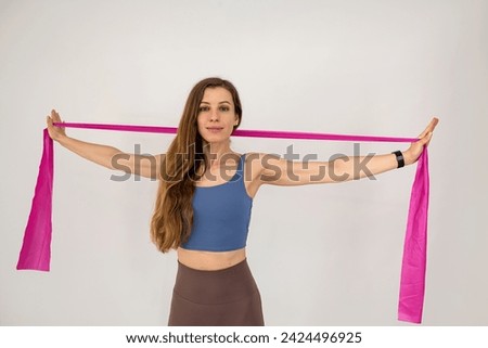 Slim caucasian woman during workout training muscles using rubber bands  isolated on white. Healthy lifestyle