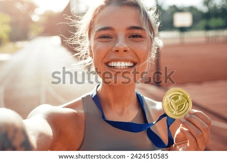 Winner woman in sportswear with number showing gold medal for first place and celebrating. Sports,  victory concept. Royalty-Free Stock Photo #2424510585