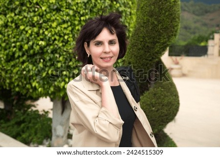 Photo of a woman 40-44 years old in a light jacket outdoors. Royalty-Free Stock Photo #2424515309