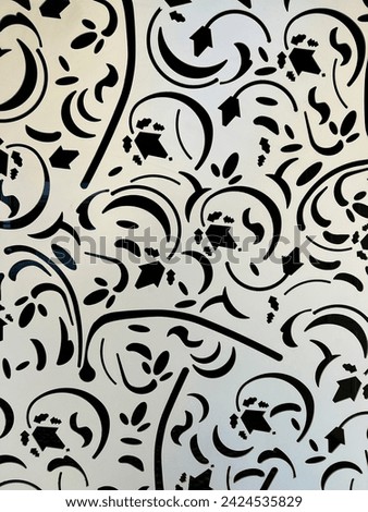A detailed shot of a monochrome pattern on a wall, showcasing the intricate symmetry and artistic motif in a rectangular format. A mix of visual arts and creative arts inspired by botany