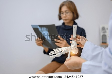 Asian female orthopedist Pointing to the ankle and foot bone model is explaining the patient's foot bone problems. Concept of health care for feet and foot bones