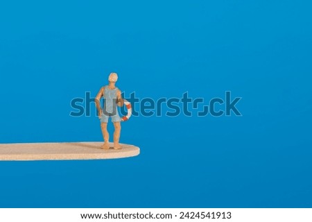 Swimmer with lifebuoy on a diving board, blue background