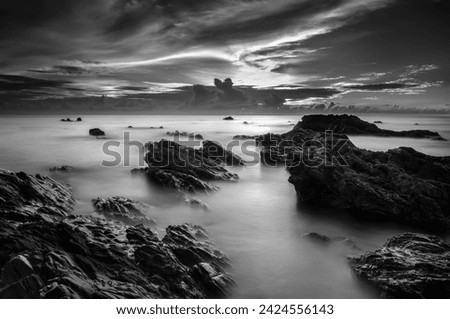 Long exposure photo of rocky beach and Glorious morning sunrise  . black and white photography.