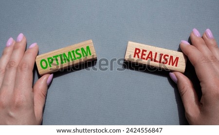 Optimism or Realism symbol. Concept word Optimism or Realism on wooden blocks. Businessman hand. Beautiful grey background. Business and Optimism or Realism concept. Copy space