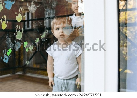 A boy paints with palms on the window. Quarantine Stay at home