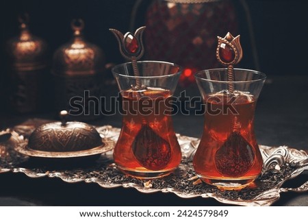 Delicious Turkish  tea in traditional  glass cups armudu  on metal tray, selective focus with shallow depth of field 