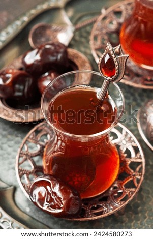 Turkish  tea in glass cup  with date fruit in traditional copper serving set,  selective focus with shallow depth of field