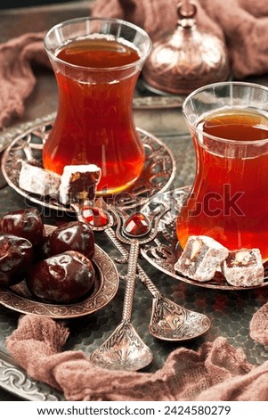 Turkish  tea in glass cup  with rahat-lokum in traditional copper serving set, selective focus with shallow depth of field 