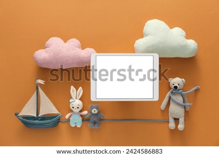 Modern tablet and toys on brown background, flat lay. Space for text