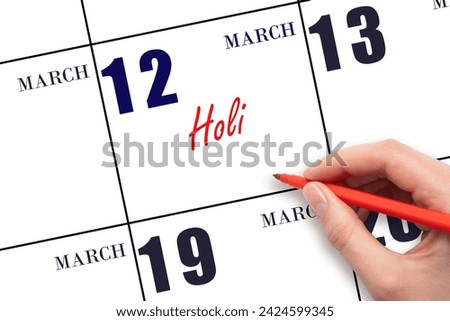 March 12. Hand writing text Holi on calendar date. Save the date. Holiday.  Day of the year concept.