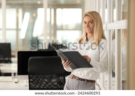 Smiling woman with folder in office, space for text. Lawyer, businesswoman, accountant or manager Royalty-Free Stock Photo #2424600293