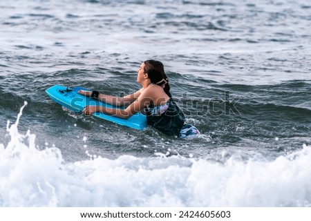 boogie boarding surfing on the waves of hawaii  Royalty-Free Stock Photo #2424605603