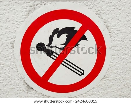 A sign prohibiting smoking in public places. An image of a crossed-out smoking cigarette in a red circle. The harm of smoking and tobacco. Air and environmental pollution. Ecology. Dependence. Royalty-Free Stock Photo #2424608315