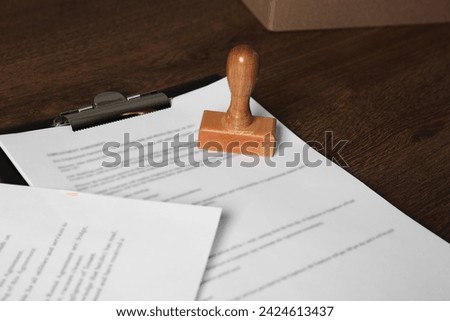 Documents and stamp on wooden table. Notary contract