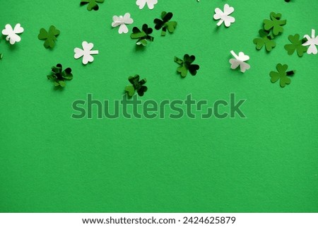 Saint Patrick's Day green background with green and white shamrock or four-leaf clover confetti, St. Patty's Day Royalty-Free Stock Photo #2424625879