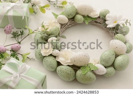 Easter wreath with white flowers, eggs and butterflies on light background Royalty-Free Stock Photo #2424628853