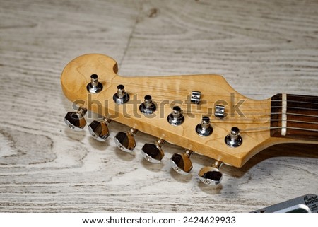 Music, pop, rock: electric guitar, Stratocaster shape, close-up of headstock with pegs and strings Royalty-Free Stock Photo #2424629933