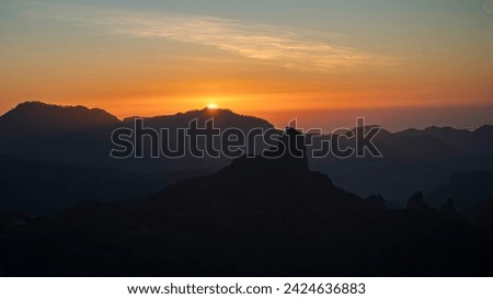 Sunset with the silhouette of Roque Bentayga and Roque Nublo on the island of Gran Canaria Royalty-Free Stock Photo #2424636883