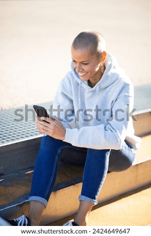 Portrait smiling with woman short hair looking at mobile phone in hand