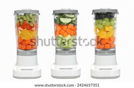 Stationary blender set fills colorful cucumber, carrot, celery for making smoothie. food drink mixed vegetable in electronic blender preparing for making healthy  smoothie isolated on white.  Royalty-Free Stock Photo #2424657351