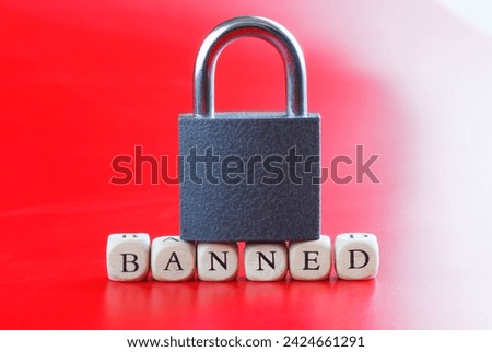 Inscription banned with closed padlock on it. Red and white background. Concept of banned internet forum, chat room, website, account, internet restriction. Photo. Close-up