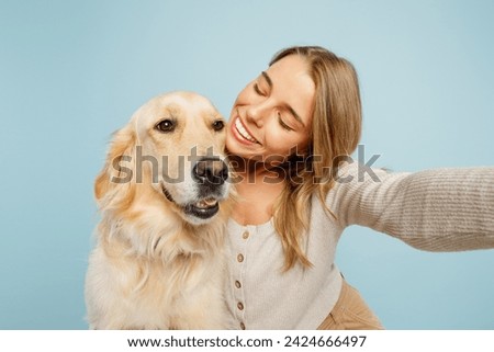 Close up young owner woman with her best friend retriever wear casual clothes do selfie shot on mobile cell phone hug dog isolated on plain pastel light blue background. Take care about pet concept