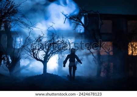 Silhouette of person standing in the dark forest with light. Horror halloween concept. strange silhouette at abandoned building