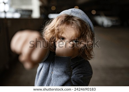 Aggressive child fight. Little kid boy fighting outside. Angry little boy showing fist. Portrait of fight kid. Bullied, physical abuse, children fighting. Aggression little boy. Kids bad behavioral. Royalty-Free Stock Photo #2424690183