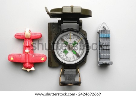 Flatlay picture of compass with miniature plan and ship. Marine and aviation navigation.