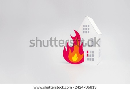 Paper cut of a house engulfed in flames. Minimum fire safety concept. Copy space