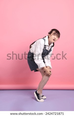 Cheerful lovely young asian woman in overalls casual clothes with gesture of sickness isolated on pink background. St Valentine's Day, Women's Day, Birthday