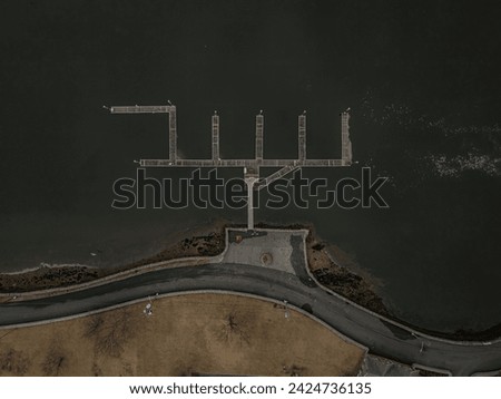 A top down, drone view directly over an empty marina in New Rochelle, New York on a cloudy day. The dock looks like a menorah. Royalty-Free Stock Photo #2424736135