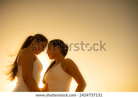 portrait of two women with long hair and looking at each other while walking in the open air. 