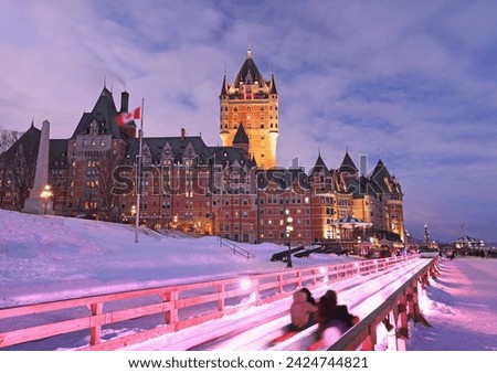 Traditional slide descent in winter in Quebec City with Frontenac Castle illuminated at dusk Royalty-Free Stock Photo #2424744821