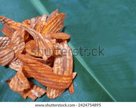 Picture of dried banana slices placed on banana leaves.