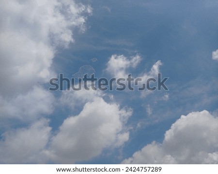 A beautiful photo of a blue sky with white clouds. The clouds have different shapes and sizes, some fluffy and some wispy.