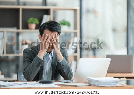 Young Stressed Out Businessman Using Laptop Computer in Modern Office. Manager Thinks About Successful Financial Ideas. Happy Man Smiling About Finding Problem Solving Solutions for Company.