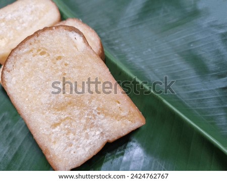Picture of bread with butter, milk, sugar placed on a banana leaf.
