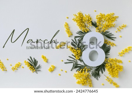 8 March celebration with number eight and text decorated with spring mimosa flowers top view. Happy Women Day white festive background. Royalty-Free Stock Photo #2424776645