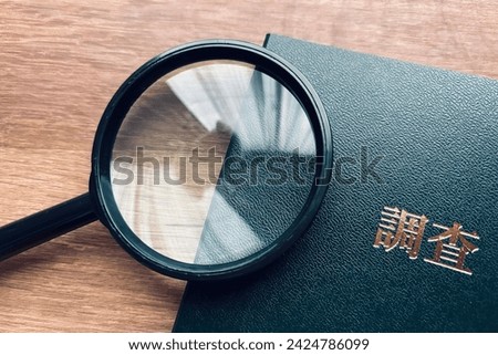 Image and magnifying glass to investigate, translation: "survey" Royalty-Free Stock Photo #2424786099