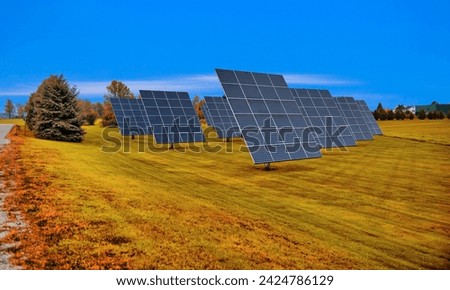 Aerial photo above solar panels in sunny rural area with green lands and a blue sky