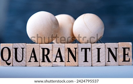 QUARANTINE - word on wooden blocks on dark blue background. Info concept