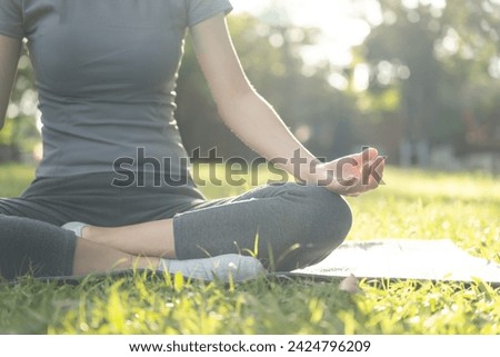woman practicing meditate on the park. Asian woman doing exercises in morning. balance, recreation, relaxation, calm, good health, happy, relax, healthy lifestyle, reduce stress, peaceful, Attitude. Royalty-Free Stock Photo #2424796209