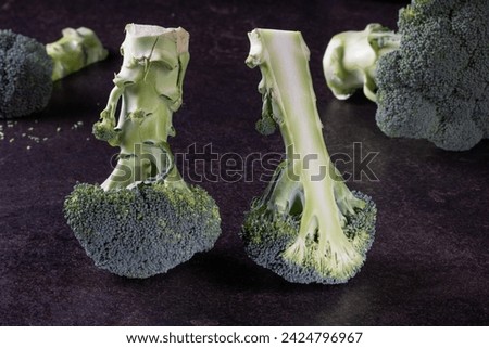 Close-up of fresh green broccoli florets meticulously arranged on a sophisticated black background. Ideal for recipe books or food magazines, emphasizing healthy eating and nutritious food choices.