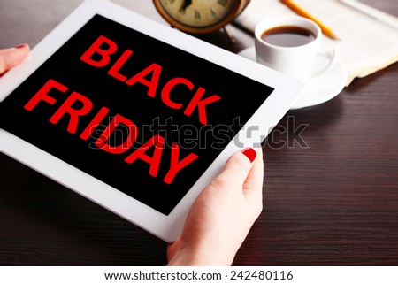 Hands holding tablet with Black Friday text on screen, Black Friday concept