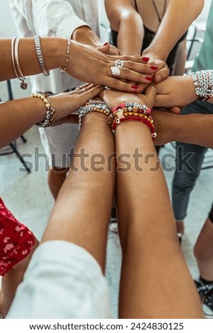 Hands clasped, joined one on top of the other, in the middle of a crowd of people. concept of unity and fellowship. Photo vertical.